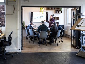 A man is giving a pitch presentation in an office