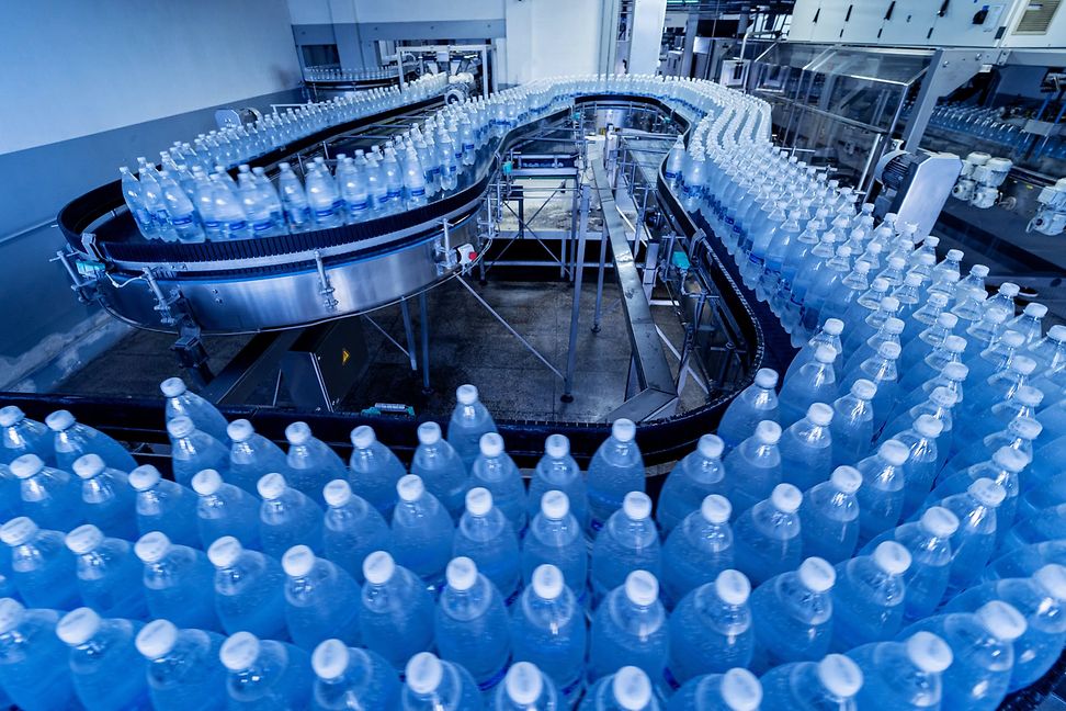Fliessband mit Trinkwasserflaschen in einer modernen Getränkefabrik 