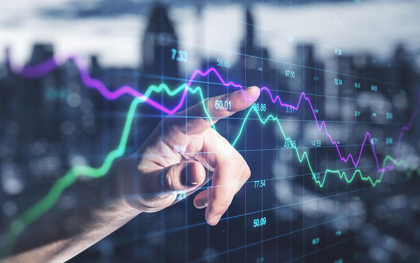 a hand pointing at a stock market graph