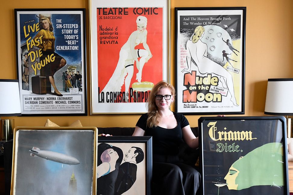 Angelina Lippert zwischen Vintage-Plakaten des Poster House
