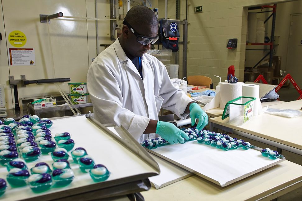 Männlicher Angestellter arbeitet in einem Labor mit Waschmittel Tabs.