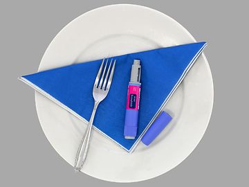 A white plate with a fork and a medicine pen on a blue napkin.