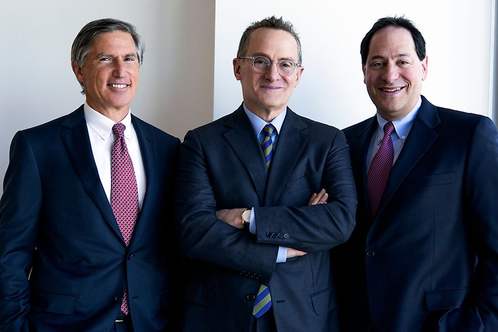 Three men in suits and ties, studio portrait.